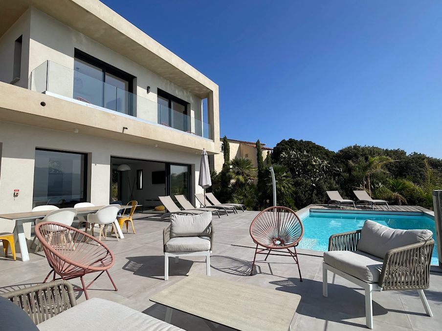 Vue de la villa d'architecte sur deux niveaux avec sa terrasse et sa piscine chauffée